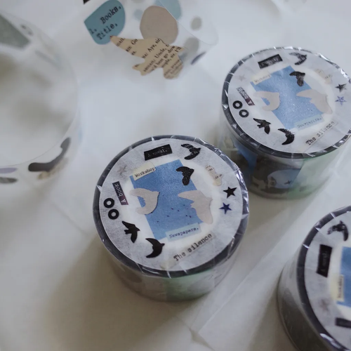 Mr. Eggplants Paper Birds PET Tape, 3cm wide, featuring stylized glossy bird silhouettes inspired by traditional paper cutting with white ink details. Ruban adhésif PET "Paper Birds" par Mr. Eggplants, 3 cm de large, avec des silhouettes d'oiseaux stylisées inspirées du découpage de papier traditionnel.