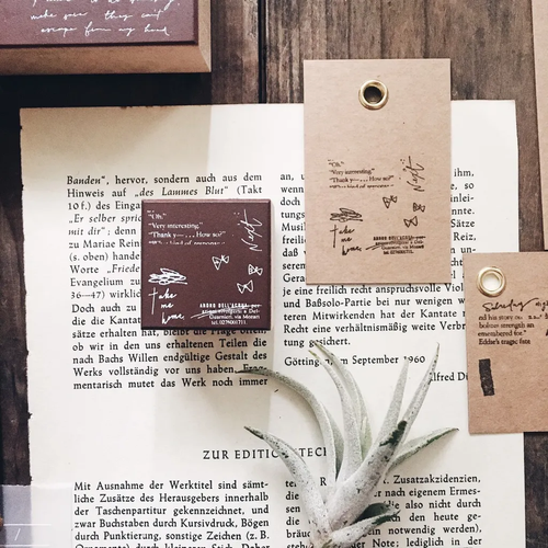 Mr. Eggplants Rubber Stamp Doodle Notes S, 3x3 cm, featuring a vintage-style butterfly or seagull and flower illustration on a wooden handle. Tampon en caoutchouc Mr. Eggplants Doodle Notes S, 3x3 cm, avec une illustration de style vintage représentant un papillon ou une mouette avec des fleurs.