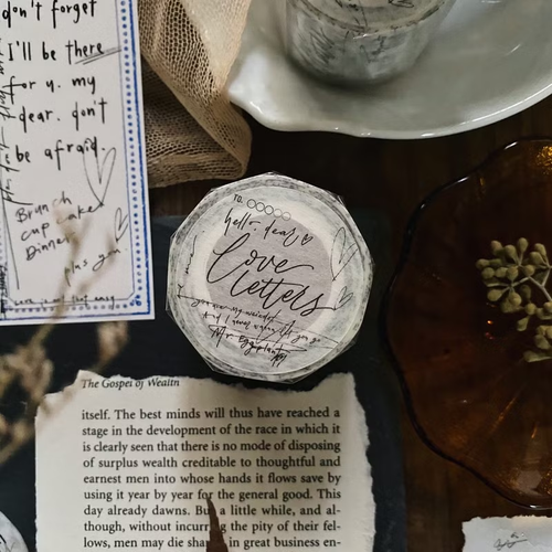 Mr. Eggplants Love Letters Washi Tape, 3.5cm wide, featuring vintage-style hand-drawn envelopes, botanical sketches, and poetic script on Japanese washi paper. Ruban adhésif washi Mr. Eggplants "Love Letters", 3,5 cm de large, avec des enveloppes de style vintage, des croquis botaniques et une écriture poétique sur du papier washi japonais.