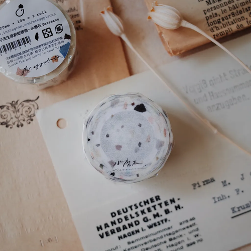 Mr. Eggplants Terrazzo Washi Tape, 2cm wide, featuring a modern mosaic stone pattern printed on matte Japanese washi paper. Ruban adhésif washi Mr. Eggplants "Terrazzo", 2 cm de large, avec un motif moderne de mosaïque de pierre imprimé sur papier washi mat.