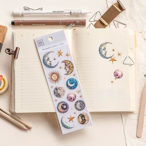 MU Whispered Corners Sticker 03 Moon and Stars. A sheet of die-cut PET stickers featuring delicate celestial line art and lunar phases for journal corners. Autocollants MU Whispered Corners 03 Moon and Stars. Une planche d'autocollants en PET avec des dessins célestes et des phases de lune pour les coins d'agenda.