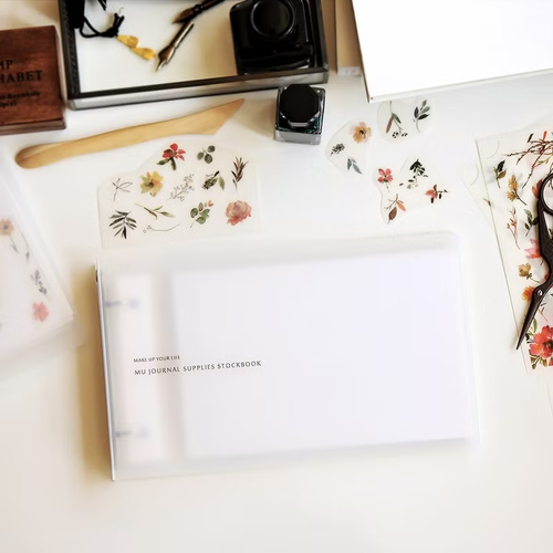MU Journal Supplies Stockbook. A loose-leaf binder with 5 self-adhesive pages for storing sticker scraps, tickets, and washi tape samples. Classeur de fournitures de journal MU. Un classeur à feuilles mobiles avec 5 pages auto-adhésives pour ranger des chutes d'autocollants et tickets.