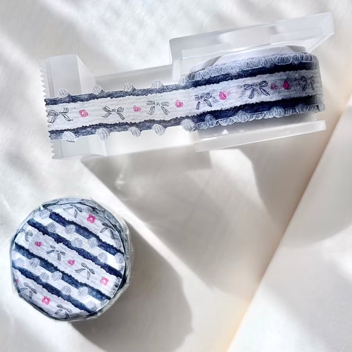 Pion Ribbon Washi Tape Tassel. A 1.5cm wide washi tape with shaped edges featuring a continuous row of illustrated pom-pom style tassels. Ruban adhésif Washi déco Pion Tassel (流蘇). Un ruban de 1,5 cm aux bords découpés illustrant une rangée continue de glands en forme de pompons.