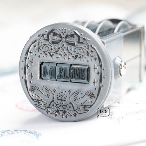 Lin Chia Ning "Birdy" Date Stamp. A vintage-style circular stamp featuring bird and floral frames with a rotating YYYY.MM.DD date center. Tampon dateur "Birdy" par Lin Chia Ning. Un tampon circulaire de style vintage avec des cadres d'oiseaux et de fleurs et une date rotative.