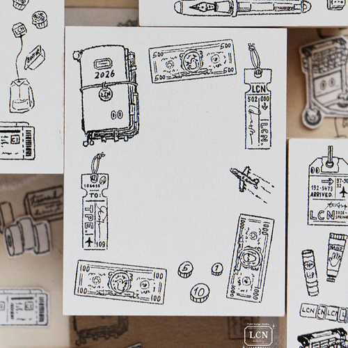 Lin Chia Ning "Travel 2" Rubber Stamp. A large 6.5x5cm vintage-style stamp featuring a frame of a TRAVELER’S Notebook, luggage tags, banknotes, and coins. Tampon en caoutchouc Lin Chia Ning "Voyage 2". Un grand tampon vintage de 6,5x5cm représentant un cadre avec un TRAVELER’S Notebook, des étiquettes de bagages, des billets et des pièces.