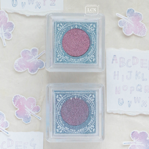 Lin Chia Ning "Star Ripple" Double-Colour Ink Pad. A square ink pad featuring a side-by-side split of light pink and light blue ink for gradient stamping. Encreur bicolore Lin Chia Ning "Star Ripple". Un tampon encreur carré avec une séparation rose clair et bleu clair pour des impressions en dégradé.