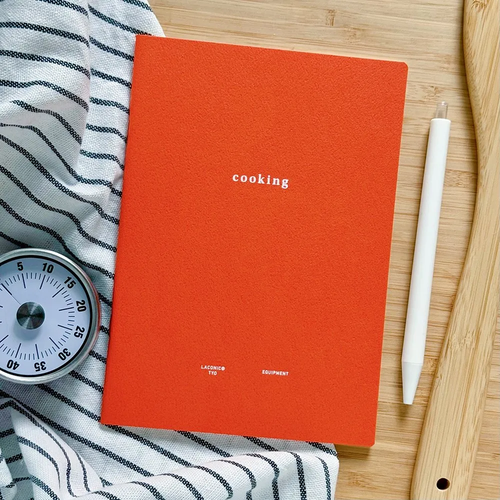 LACONIC Style Notebook B6 Cooking edition. A minimalist cream-colored recipe journal showcasing a structured page layout for ingredients, instructions, grid-lined preparation methods, and a difficulty level rating index. / Carnet de recettes LACONIC Style Notebook B6 Édition Cooking. Un journal de cuisine minimaliste à la couverture crème, présentant des pages structurées pour les ingrédients, une grille pour les instructions et un index de notation.