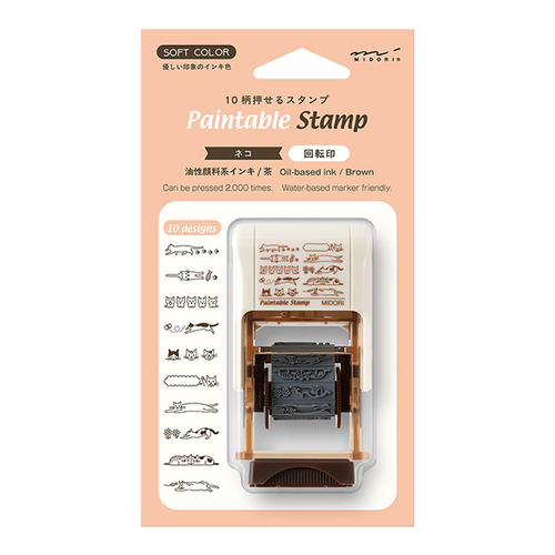 Midori paintable rotating stamp Cat theme in a brown body, featuring 12 unique illustrations of cats in different poses and markings designed by Sayo Koizumi. / Tampon rotatif à peindre Midori thème Chat, corps marron, avec 12 illustrations uniques de chats dans différentes poses et avec différents marquages conçues par Sayo Koizumi.