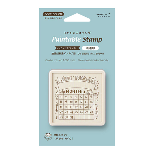 Midori pre-inked paintable stamp Habit Tracker Cat theme in a brown square body. Shows a soft brown ink routine tracking grid decorated with cute cat illustrations designed by Sayo Koizumi. / Tampon auto-encreur à peindre Midori thème Suivi des Habitudes Chat, boîtier carré marron. Montre une grille de suivi à l'encre marron clair ornée de jolies illustrations de chats conçues par Sayo Koizumi.