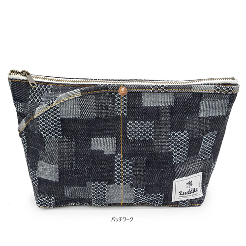 Luddite Denim Boat Pouch M in unique random patchwork Okayama denim from the Authentic Denim series. Compact boat-shaped design with metal zipper, internal zippered divider pocket, and vintage workwear stitching and labels. One-of-a-kind pattern placement. Made in Japan. Pochette bateau en denim Luddite M au motif patchwork aléatoire unique en denim Okayama de la série Authentic Denim. Design compact en forme de bateau avec fermeture éclair métallique, poche intérieure zippée et détails workwear vintage (coutures et étiquettes). Motif unique sur chaque pièce. Fabriquée au Japon.