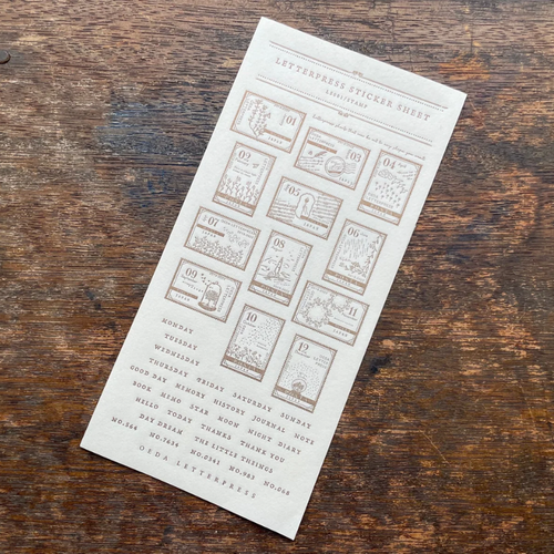 OEDA LETTERPRESS Sticker Sheet Stamp in Bronze showing press-printed numbered stamp designs 1 to 12 on heavy adhesive paper. / Feuille d'autocollants OEDA LETTERPRESS Stamp en Bronze présentant des motifs de timbres numérotés de 1 à 12 imprimés en typographie sur papier adhésif épais.