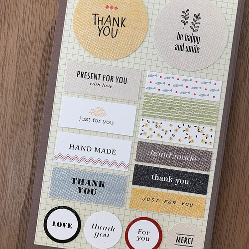 Suatelier Sticker sheet featuring stickers marked Thank You in various patterns, shapes, and colors. / Planche d'autocollants Suatelier présentant des autocollants marqués Merci avec différents motifs, formes et couleurs.