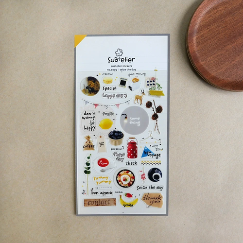 Suatelier Sticker sheet featuring daily life items like a toaster, macarons, blueberries, and uplifting phrases. / Planche d'autocollants Suatelier présentant des objets du quotidien comme un grille-pain, des macarons, des myrtilles et des phrases inspirantes.