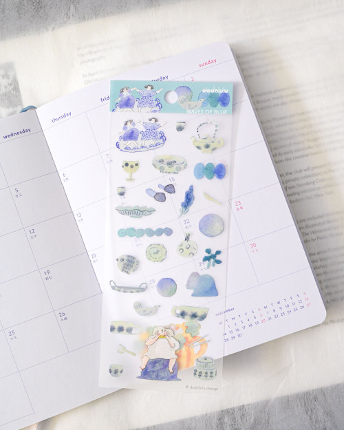 dodolulu Matte Sticker Sheet Waves of Blue featuring soothing ocean tides and blue-themed illustrations. / Planche d'autocollants mats dodolulu Waves of Blue présentant des marées apaisantes et des illustrations dans les tons bleus.