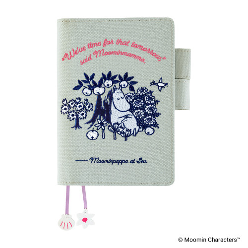 Hobonichi Techo A6 Original Cover Moomin: My Yard (Pale Mint). Pale-mint cotton cover with navy embroidered sleeping Moominmamma, a stitched quote, island family scene and shell and flower bookmark charms. Couverture Hobonichi Techo A6 Original Moomin : My Yard (Pale Mint). Coton menthe pâle brodé marine de Moominmamma endormie, citation brodée, scène familiale sur l’île et breloques coquillage et fleur.