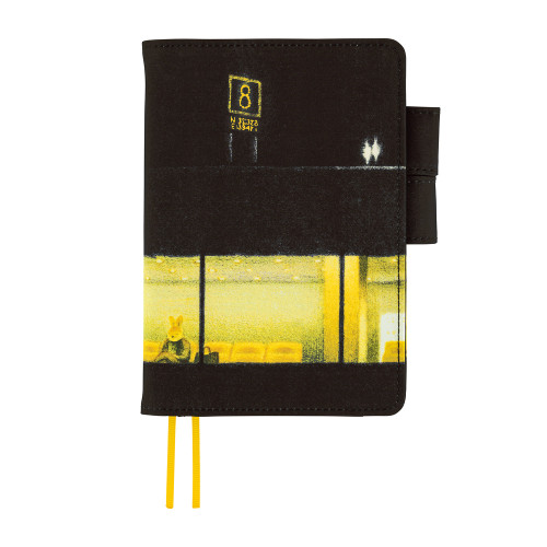 Hobonichi Techo A6 Original Cover Akiko Miyakoshi: An Airport at Night. Textured polyester cover with a continuous night-airport scene in warm yellow light, yellow ribbon bookmarks and a hidden pocket detail. Couverture Hobonichi Techo A6 Original Akiko Miyakoshi : An Airport at Night. Polyester texturé, scène d’aéroport de nuit en lumières jaunes continues, signets jaune vif et détail caché dans la poche.