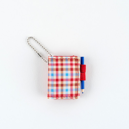 Hobonichi Techo Mini Keychain Bright Plaid. Miniature bright-plaid techo keychain with butterfly-stopper holders, a writable 40-page grid notebook and a removable brass ball chain. Mini porte-clés Hobonichi Techo Bright Plaid. Mini techo à carreaux vifs avec porte-stylos papillon, carnet quadrillé de 40 pages et chaînette en laiton amovible.