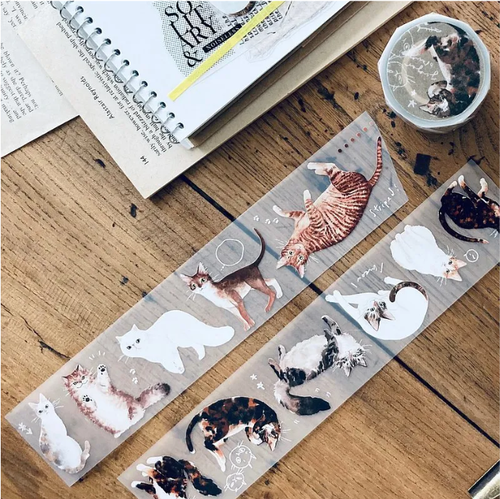 Some Sort of Fern PET Tape Ginger (5 cm). A 5 cm × 10 m matte PET roll of cats on a turmeric-yellow ground, 100 cm loop. Ruban PET Some Sort of Fern Ginger (5 cm). Rouleau PET mat 5 cm × 10 m de chats sur fond jaune curcuma, motif 100 cm.