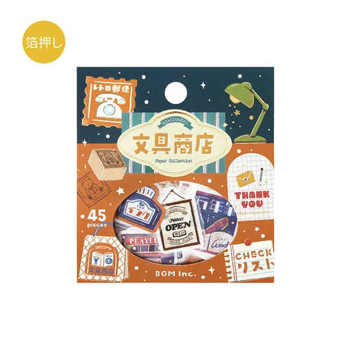 BGM Retro Stroll Sticker Set Stationery Store. A foil-stamped flake pack of 45 stationery-shop stickers (15 designs × 3) in a 90 × 100 mm sleeve. Set d’autocollants BGM Retro Stroll Stationery Store. 45 stickers papeterie dorés (15 motifs × 3), pochette 90 × 100 mm.