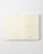 Minimalist Midori MD Notebook A6 size blank edition, showing its signature cream cover, exposed cheesecloth thread binding, and blank unlined pages. / Carnet minimaliste Midori MD Notebook taille A6 édition vierge, montrant sa couverture crème emblématique, sa reliure au fil apparente et ses pages blanches unies.