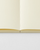 Minimalist Midori MD Notebook A6 size blank edition, showing its signature cream cover, exposed cheesecloth thread binding, and blank unlined pages. / Carnet minimaliste Midori MD Notebook taille A6 édition vierge, montrant sa couverture crème emblématique, sa reliure au fil apparente et ses pages blanches unies.