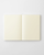 Minimalist Midori MD Notebook A6 size blank edition, showing its signature cream cover, exposed cheesecloth thread binding, and blank unlined pages. / Carnet minimaliste Midori MD Notebook taille A6 édition vierge, montrant sa couverture crème emblématique, sa reliure au fil apparente et ses pages blanches unies.