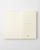 Minimalist Midori MD Notebook in B6 Slim size with blank cream pages. Exposed cheesecloth spine lies completely flat next to its signature colourful bookmark string. / Carnet minimaliste Midori MD Notebook de taille B6 Slim avec pages crème vierges. Le dos en gaze exposé repose entièrement à plat à côté de son ruban marque-page coloré signature.