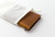 TRAVELER'S Notebook Starter Kit Passport Size in Camel. A rustic camel leather cover with a blank notebook refill, green spare elastic, and a cotton bag. Kit de démarrage TRAVELER'S Notebook Taille Passeport en Camel. Une couverture en cuir camel rustique avec une recharge de carnet vierge et un élastique de rechange vert.