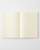 Minimalist MD Notebook A5 with an exposed fabric spine and a cream-colored paper cover wrap. It is shown open 180 degrees flat, displaying its ink-friendly pages. / Carnet minimaliste MD Notebook A5 avec reliure apparente en tissu et couverture en papier crème, ouvert à 180 degrés à plat pour montrer ses pages adaptées aux stylos plume.