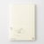 Minimalist MD Notebook A5 with an exposed fabric spine and a cream-colored paper cover wrap. It is shown open 180 degrees flat, displaying its ink-friendly pages. / Carnet minimaliste MD Notebook A5 avec reliure apparente en tissu et couverture en papier crème, ouvert à 180 degrés à plat pour montrer ses pages adaptées aux stylos plume.