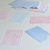 A stack of B6 letter paper from the Classiky Mitsou collection, showing six patterned designs including polka dots, stripes, and grid by Mariko Okumura. Une pile de papier à lettres B6 de la collection Classiky Mitsou, présentant six motifs différents incluant des pois, des rayures et une grille par Mariko Okumura.
