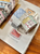 Pion Washi Tape Spring. A 3cm wide washi tape featuring a patchwork collage of floral illustrations and textile patterns in warm spring colors. Ruban adhésif Washi Pion Spring (春野小徑). Un ruban de 3 cm de large présentant un collage patchwork d'illustrations florales et de motifs textiles dans des tons printaniers chauds.