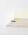 MIDORI MD Notebook A5 Grid. A minimalist cream-colored notebook with light blue 5mm grid pages and an exposed thread-bound spine. Carnet MIDORI MD Notebook A5 Grid. Un carnet minimaliste couleur crème avec des pages quadrillées de 5 mm en bleu clair et une reliure cousue apparente.