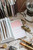 Lin Chia Ning 2026 Mini Tote Stationery Set featuring a black leather mini journal, star brass charm, and tiny stamps inside a canvas tote. Coffret de papeterie Lin Chia Ning 2026 comprenant un mini carnet en cuir noir, une breloque étoile en laiton et des tampons miniatures dans un mini sac en toile.