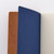 TAKEO PAPER Dressco Stitch Notebook Bister edition. A slim, palm-sized notebook featuring a leather-textured bister brown paper cover, stitched spine, and premium blank Bank Paper pages embedded with a Three Diamonds watermark. / Carnet cousu TAKEO PAPER Dressco Édition Bister. Un carnet de poche mince arborant une couverture en papier brun bister texture cuir, une reliure cousue et des pages blanches en papier de banque haut de gamme.