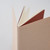 TAKEO PAPER Dressco Stitch Notebook Vellum edition. A slim, palm-sized notebook featuring a leather-textured vellum tan paper cover, stitched spine, and premium blank Bank Paper pages embedded with a Three Diamonds watermark. / Carnet cousu TAKEO PAPER Dressco Édition Vellum. Un carnet de poche mince arborant une couverture en papier vellum beige texture cuir, une reliure cousue et des pages blanches en papier de banque haut de gamme.