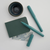 Kaweco PERKEO Breezy Teal fountain pen. Features a lightweight multi-faceted matte plastic body with a soft grey-blue barrel and a contrasting deep teal screw cap, available with a steel fine or medium nib. / Stylo-plume Kaweco PERKEO Breezy Teal. Présente un corps léger à facettes en plastique mat avec un corps bleu-gris doux et un capuchon à vis bleu sarcelle foncé contrasté, disponible avec une plume en acier fine ou moyenne.
