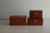 Classiky small Toga wood first aid box with a vintage design, metal latch, and folding top handle. Open view shows a removable sliding tray and a metal clip inside the lid. / Petite boîte à pharmacie Classiky en bois de Toga au design vintage, avec loquet métallique et poignée rabattable. La vue ouverte montre un plateau coulissant amovible et un clip en métal à l'intérieur du couvercle.