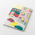 Midori Yuru Log Notebook in B6 size, Daily Life theme, showing dot grid pages with colored pencil illustrations of home, kitchen, and rooms by Rie Koizumi. / Carnet Midori Yuru Log de taille B6, thème Vie Quotidienne, montrant des pages à points avec des illustrations aux crayons de couleur de maison, cuisine et chambres par Rie Koizumi.