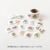 Midori Yuru Log roll sticker in Motifs theme, showing a strip of 18 unique illustrated geometric shapes and icon frames being torn from a perforated paper roll. / Rouleau d'autocollants Midori Yuru Log thème Motifs, montrant une bande de 18 formes géométriques et cadres d'icônes illustrés uniques détachée d'un rouleau de papier perforé.