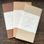 OEDA LETTERPRESS Two-Colour Paper Notebook L featuring a rustic board cover and alternating white and natural Bunpel paper pages. / Carnet de notes bicolore L OEDA LETTERPRESS présentant une couverture en carton rustique et des pages alternées en papier Bunpel blanc et naturel.
