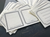 OEDA LETTERPRESS Sticker Set in Black showing textured white business card sized paper stickers with black letterpress frames. / Ensemble d'autocollants OEDA LETTERPRESS en Noir présentant des autocollants en papier blanc texturé format carte de visite imprimés en typographie noire.