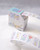 dodolulu Label Sticker Roll Reverie made of textured washi paper with shimmering foil stamping featuring 8 repeating designs. / Rouleau d'étiquettes autocollantes dodolulu Reverie en papier washi texturé avec dorure étincelante présentant 8 motifs répétés.