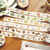 BGM Tokimeki Flavour Washi Tape Matcha (1.5 cm). A 15 mm × 5 m foil-stamped washi roll of matcha and café-sweet motifs. Ruban washi BGM Tokimeki Flavour Matcha (1,5 cm). Rouleau washi 15 mm × 5 m, matcha et douceurs de café, dorure.