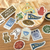 BGM Retro Stroll Sticker Set Flea Market. A foil-stamped flake pack of 45 flea-market stickers (15 designs × 3) in a 90 × 100 mm sleeve. Set d’autocollants BGM Retro Stroll Flea Market. 45 stickers marché aux puces dorés (15 motifs × 3), pochette 90 × 100 mm.