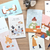 Cozyca × Mariko Fukuoka Postcard Set Meow. Ten 100 × 148 mm postcards in five cat-life designs. Set cartes postales Cozyca × Mariko Fukuoka Meow. Dix cartes 100 × 148 mm, cinq scènes de vie avec chats.