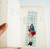 La Dolce Vita Bookmark LDV Mail. One clear PVC bookmark, 150 × 40 mm and 0.8 mm thick, sold with one paper card. Marque-page La Dolce Vita LDV Mail. Un marque-page PVC transparent, 150 × 40 mm et 0,8 mm, vendu avec une carte papier.