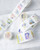 dodolulu 2027 365 Daily Washi Tape Calendar set featuring two rolls of perforated daily washi tape stickers with release paper backing. / Ensemble de rubans washi calendrier 2027 365 jours dodolulu comprenant deux rouleaux d'autocollants perforés quotidiens sur papier protecteur.
