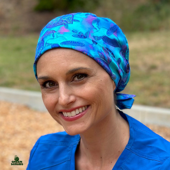 Woman looking at camera while wearing  Super Tie - Glow Turtles by Green Scrubs