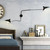 Angled view of two arm wall light highlighting asymmetrical arm lengths and sculptural mid-century design